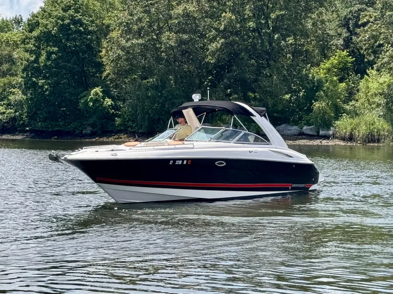 Slide: The Image of 2005 Monterey 298SS Super Sport boat cruising on a calm lake with lush green trees. - 3