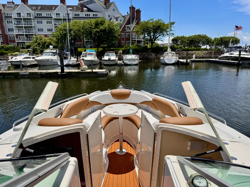 Slide: The Image of 2005 Monterey 298SS Super Sport boat docked in a scenic marina with waterfront buildings. - 6