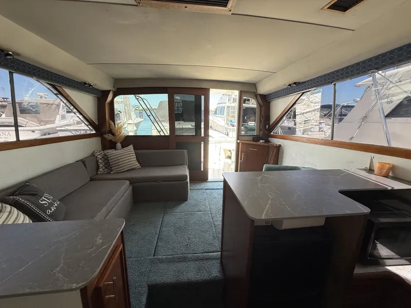 Slide: The Image of Interior of 1988 Ocean Yachts 35 Flybridge with cozy seating and marina view. - 11