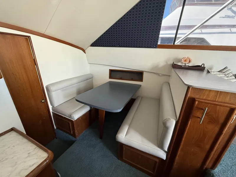 Slide: The Image of Interior of 1988 Ocean Yachts 35 Flybridge with dining area and wooden cabinetry. - 13