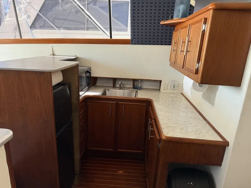 Slide: The Image of 1988 Ocean Yachts 35 Flybridge kitchen with wood cabinets, marble countertop, and appliances. - 14