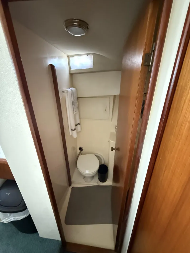 Slide: The Image of Compact bathroom in 1988 Ocean Yachts 35 Flybridge, featuring toilet and towel rack. - 15