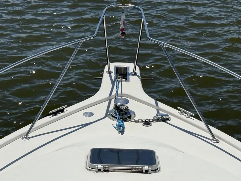 Slide: The Image of Bow view of 1988 Ocean Yachts 35 Flybridge on water, featuring anchor and railing. - 19