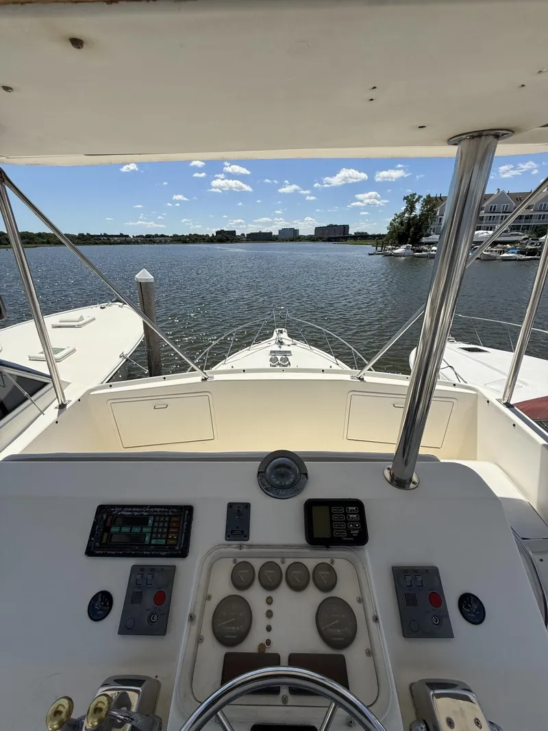 Slide: The Image of 1988 Ocean Yachts 35 Flybridge helm view, overlooking calm waters and distant buildings. - 10