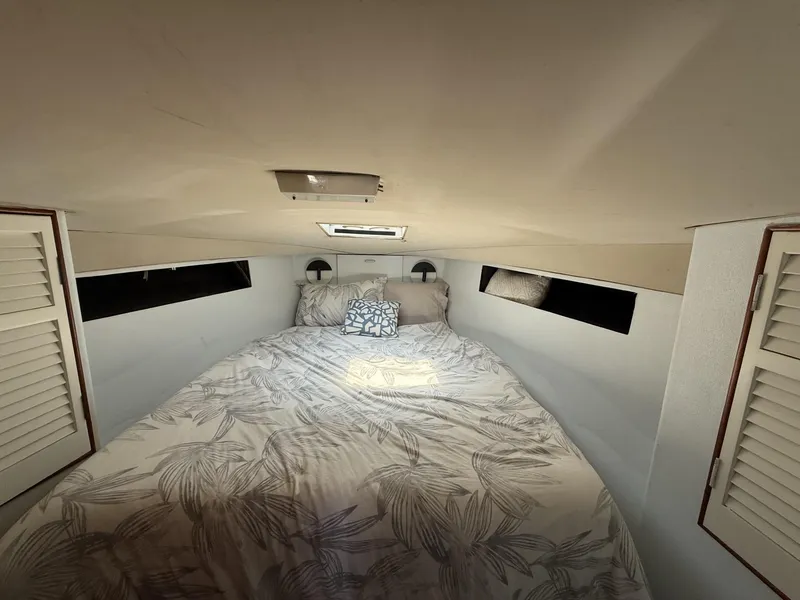 Slide: The Image of Cozy bedroom interior of 1988 Ocean Yachts 35 Flybridge with floral bedding and natural light. - 16