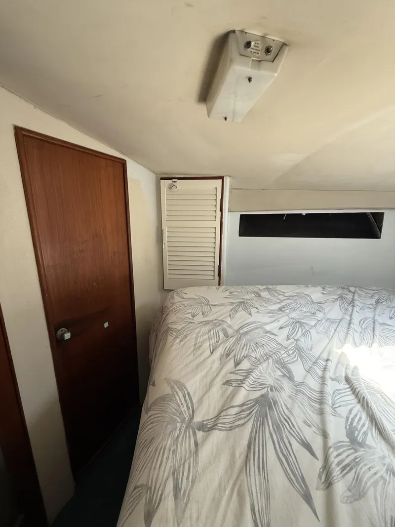 Slide: The Image of Interior cabin of 1988 Ocean Yachts 35 Flybridge with bed and wooden door. - 18