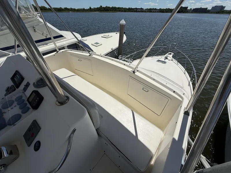 Slide: The Image of 1988 Ocean Yachts 35 Flybridge boat interior with control panel and seating, docked by the water. - 8