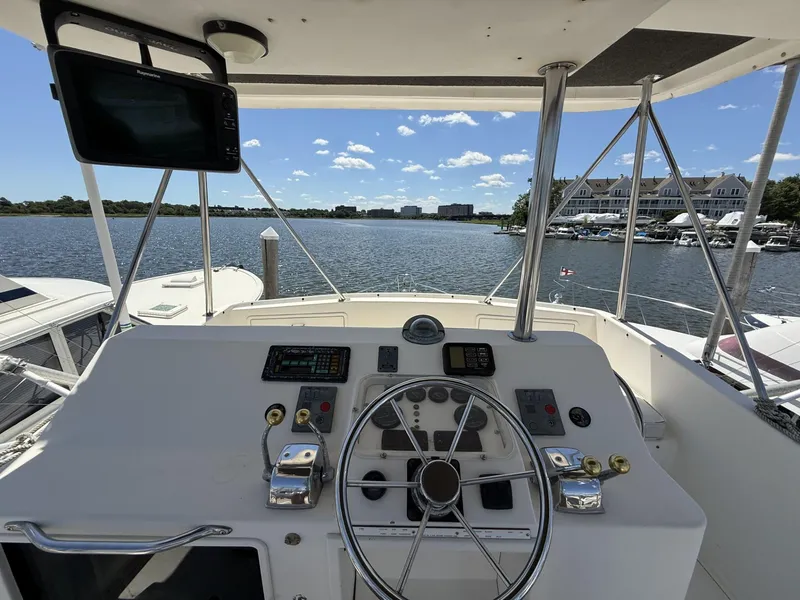 Slide: The Image of 1988 Ocean Yachts 35 Flybridge helm with steering wheel and navigation equipment, overlooking marina. - 9