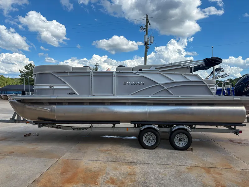 The Image of 2023 Sylvan Mirage 8522 pontoon boat on trailer under a blue sky. - 1