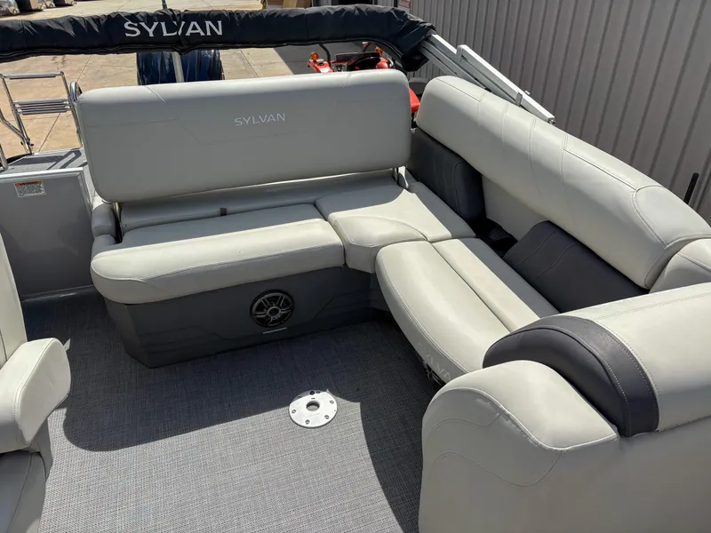 Slide: The Image of 2023 Sylvan Mirage 8522 boat interior with gray cushioned seating and speaker. - 4