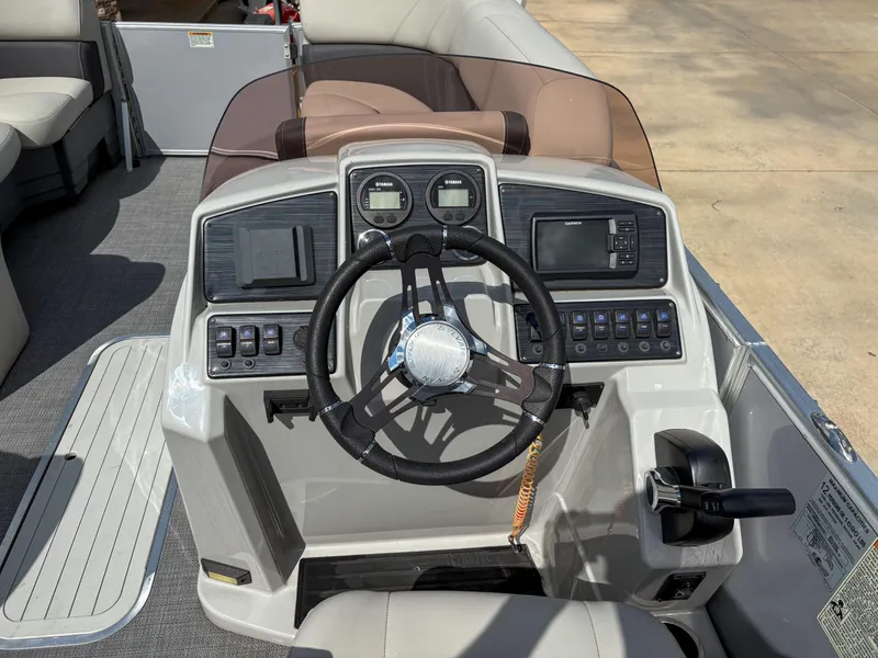 Slide: The Image of 2023 Sylvan Mirage 8522 boat dashboard with steering wheel and control panel. - 6