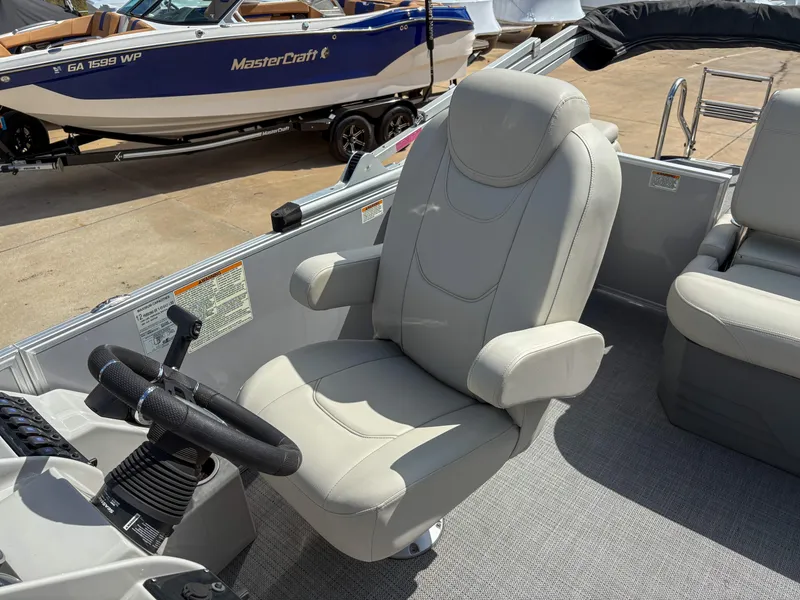 Slide: The Image of Captain's chair on 2023 Sylvan Mirage 8522 pontoon boat, with steering wheel and controls. - 8