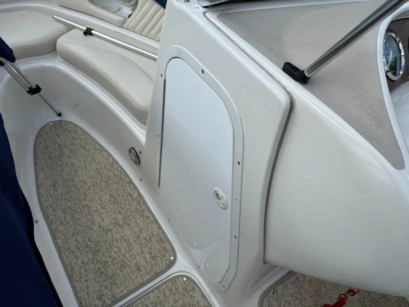 Slide: The Image of 1999 Chris-Craft 200 Bowrider SS interior with white seating and carpeted flooring. - 10