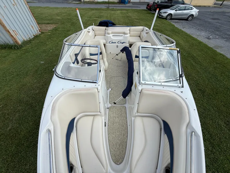 Slide: The Image of 1999 Chris-Craft 200 Bowrider SS with beige interior, parked on grass. - 12