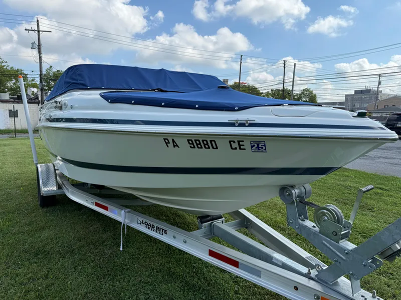 Slide: The Image of 1999 Chris-Craft 200 Bowrider SS on trailer, covered, parked on grass. - 3