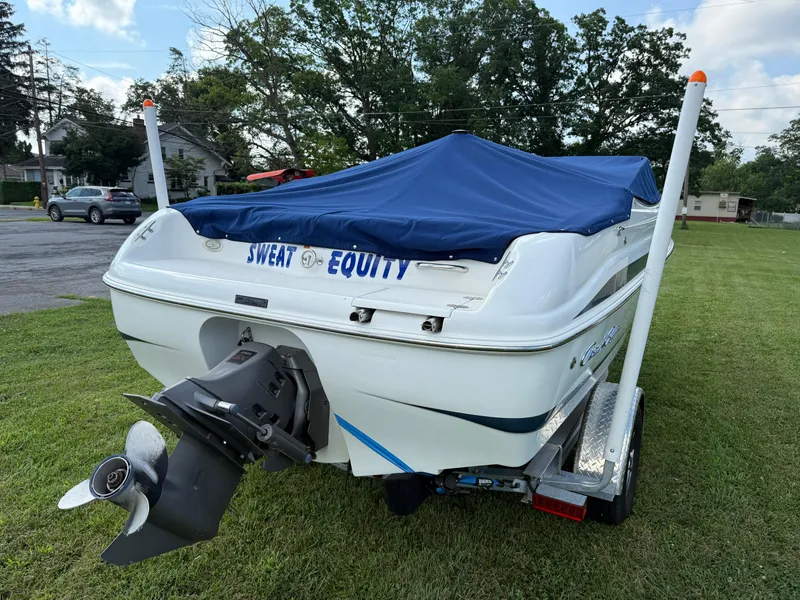 Slide: The Image of 1999 Chris-Craft 200 Bowrider SS boat with blue cover on trailer, labeled "Sweat Equity." - 4