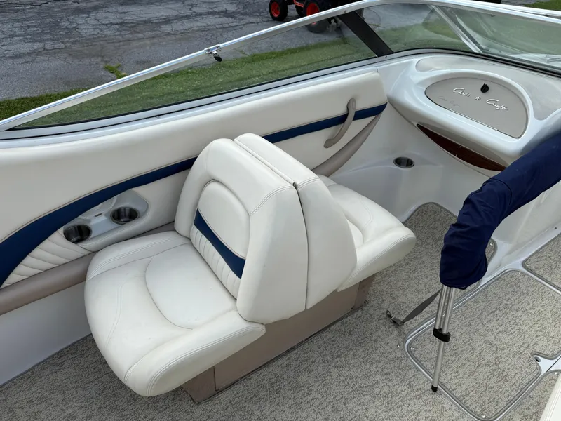 Slide: The Image of 1999 Chris-Craft 200 Bowrider SS interior with white seating and cup holders. - 8