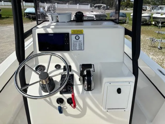 Slide: The Image of 2022 May-Craft 2300 CCX boat console with steering wheel and navigation controls. - 12
