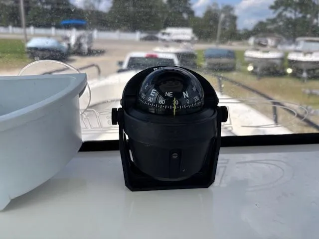 Slide: The Image of Compass on 2022 May-Craft 2300 CCX boat dashboard, with boats in the background. - 23
