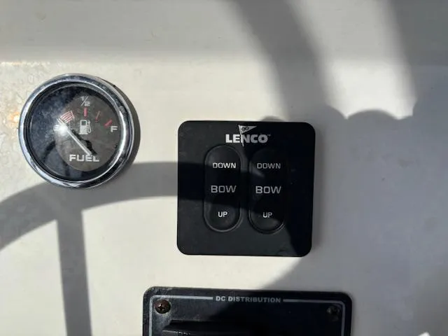 Slide: The Image of Fuel gauge and Lenco trim tab controls on 2022 May-Craft 2300 CCX boat dashboard. - 24