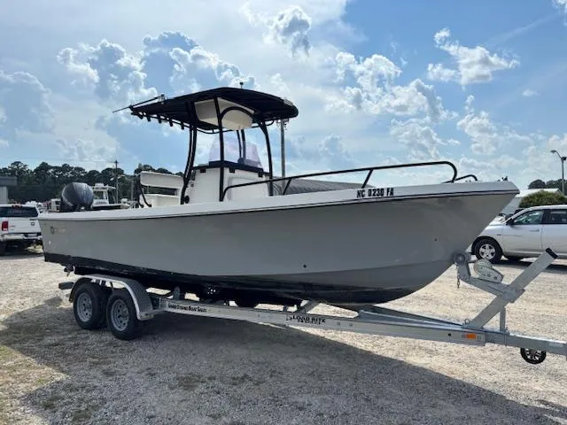 Slide: The Image of 2022 May-Craft 2300 CCX boat on trailer, parked outdoors under a cloudy sky. - 3