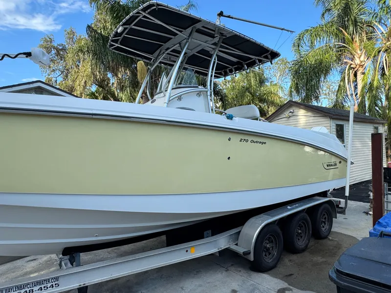 Slide: The Image of 2005 Boston Whaler 270 Outrage boat on trailer, surrounded by palm trees. - 4