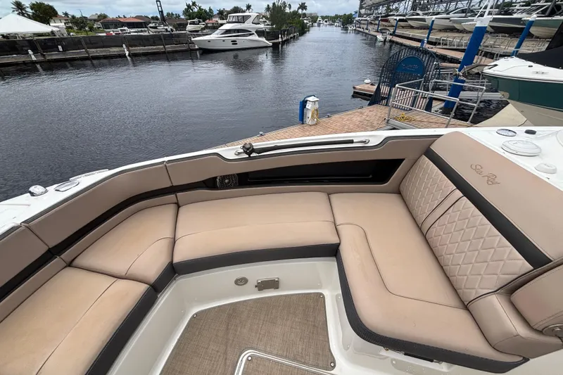 Slide: The Image of 2018 Sea Ray SLX 310 Outboard boat with luxurious seating at a marina. - 12