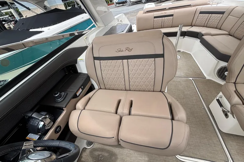Slide: The Image of 2018 Sea Ray SLX 310 Outboard interior with luxurious beige seating and modern controls. - 25