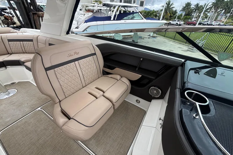 Slide: The Image of 2018 Sea Ray SLX 310 Outboard interior with beige seating and modern design. - 28