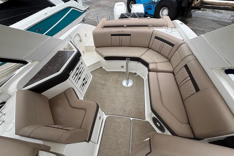 Slide: The Image of 2018 Sea Ray SLX 310 Outboard interior with beige seating and modern design. - 29
