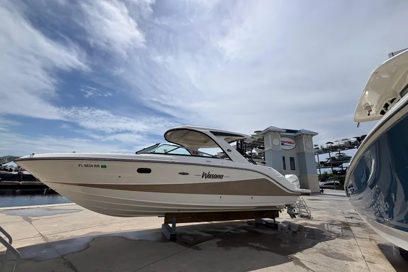 Slide: The Image of 2018 Sea Ray SLX 310 Outboard boat on display at a marina under a cloudy sky. - 3
