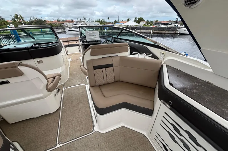 Slide: The Image of 2018 Sea Ray SLX 310 Outboard interior with beige seating and modern dashboard. - 31