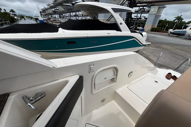 Slide: The Image of 2018 Sea Ray SLX 310 Outboard boat docked, featuring sleek design and spacious deck. - 37