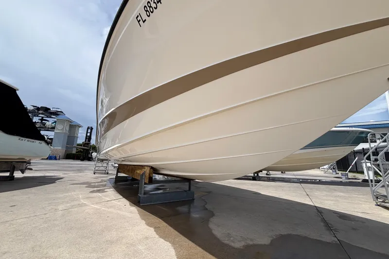 Slide: The Image of 2018 Sea Ray SLX 310 Outboard boat on dry dock, showcasing hull design. - 7