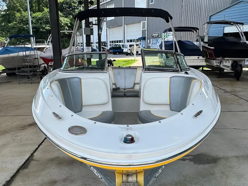 Slide: The Image of 2008 Sea Ray 185 Sport boat with white and gray seating, parked in a marina. - 14