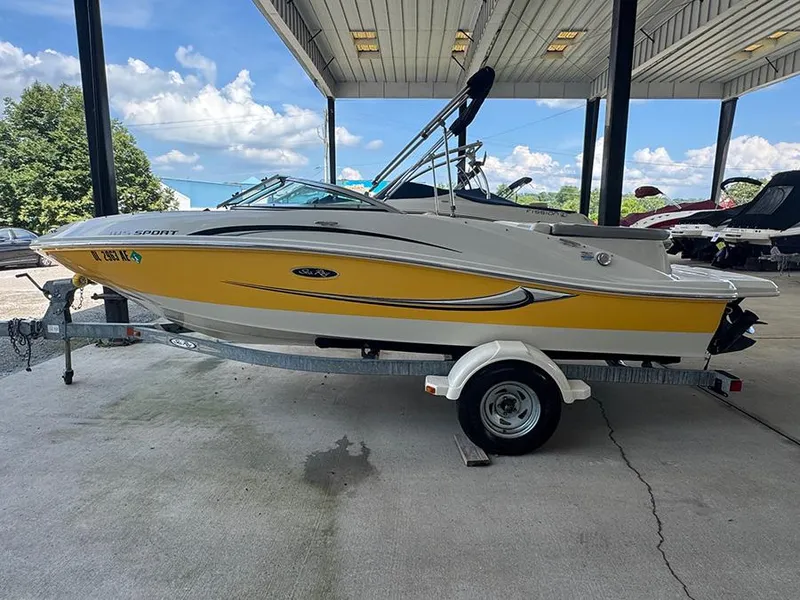 Slide: The Image of 2008 Sea Ray 185 Sport boat with yellow hull on a trailer under a canopy. - 3