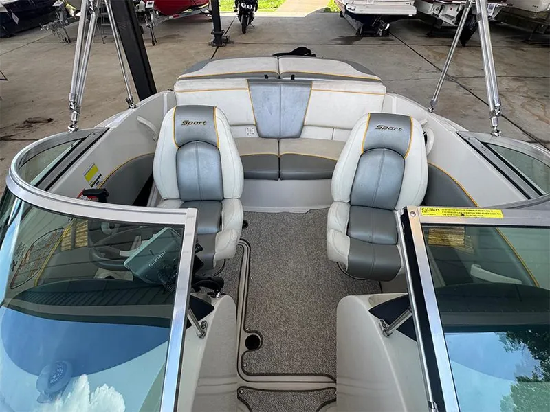 Slide: The Image of 2008 Sea Ray 185 Sport boat interior with gray and white seating, under a covered area. - 7