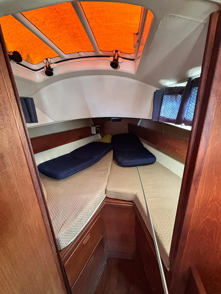 Slide: The Image of Interior cabin of a 1981 Sabre 30 sailboat with cozy bedding and wooden finish. - 10