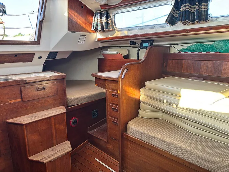 Slide: The Image of 1981 Sabre 30 sailboat interior with wooden cabinetry, seating, and nautical decor. - 11