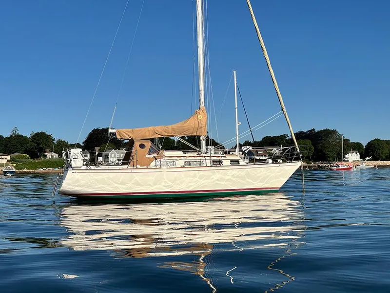 Slide: The Image of 1981 Sabre 30 sailboat on calm water, clear sky, coastal background. - 2