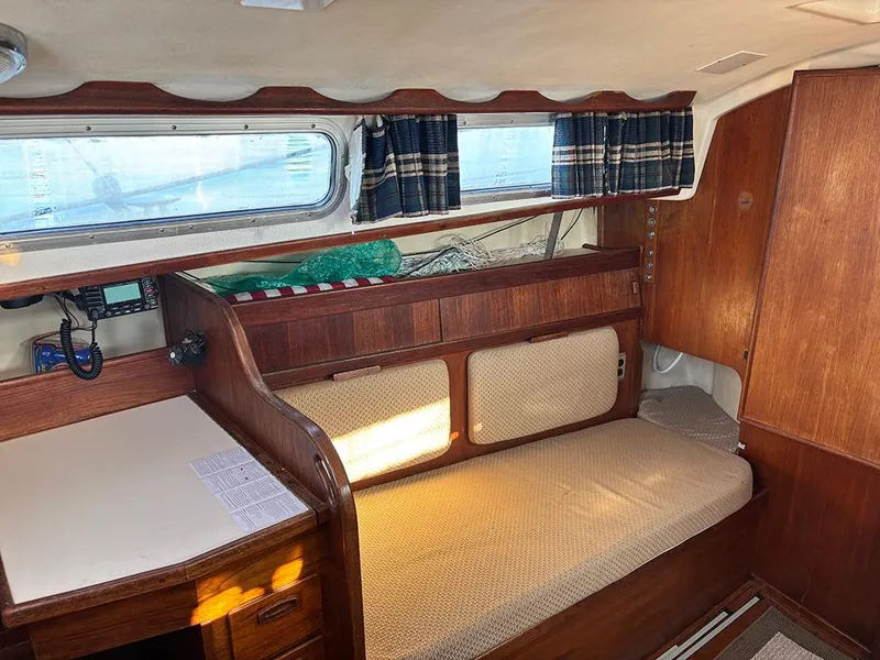 Slide: The Image of 1981 Sabre 30 sailboat interior with wood paneling, cushioned seating, and nautical decor. - 8