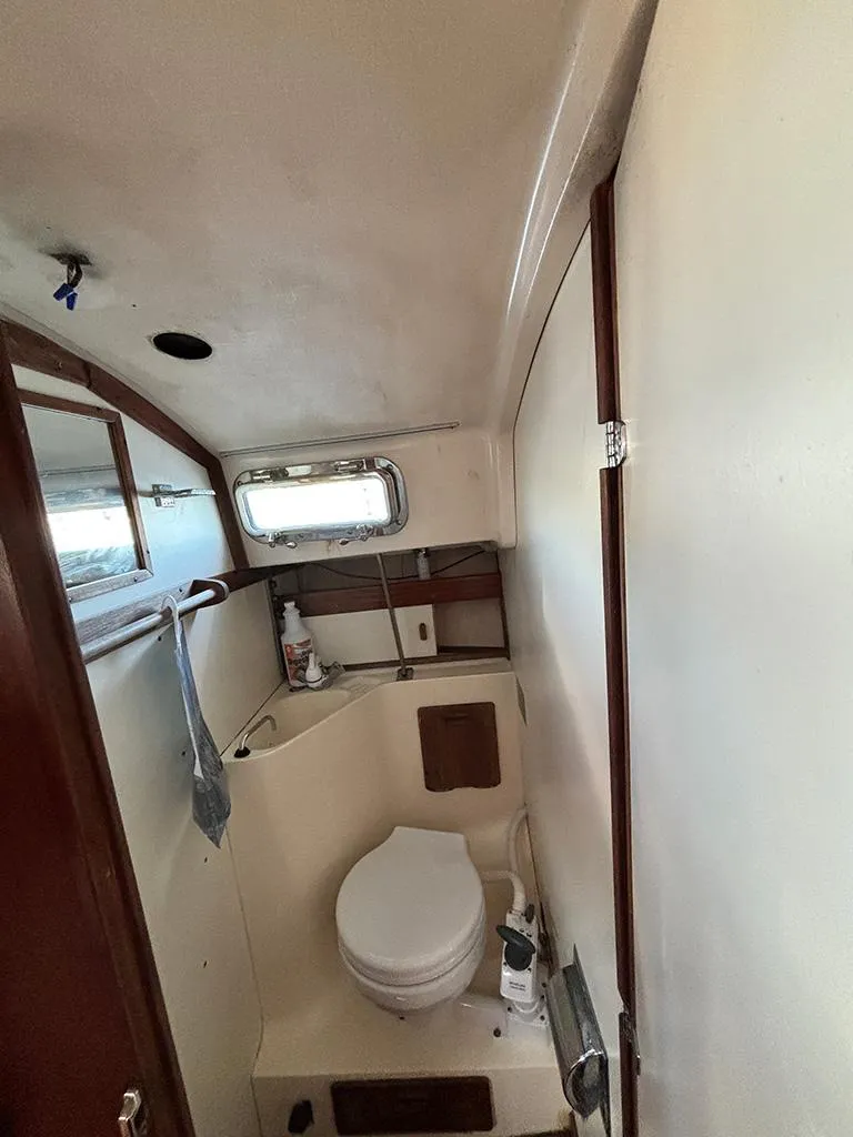 Slide: The Image of Interior of 1981 Sabre 30 sailboat bathroom with toilet and small window. - 9