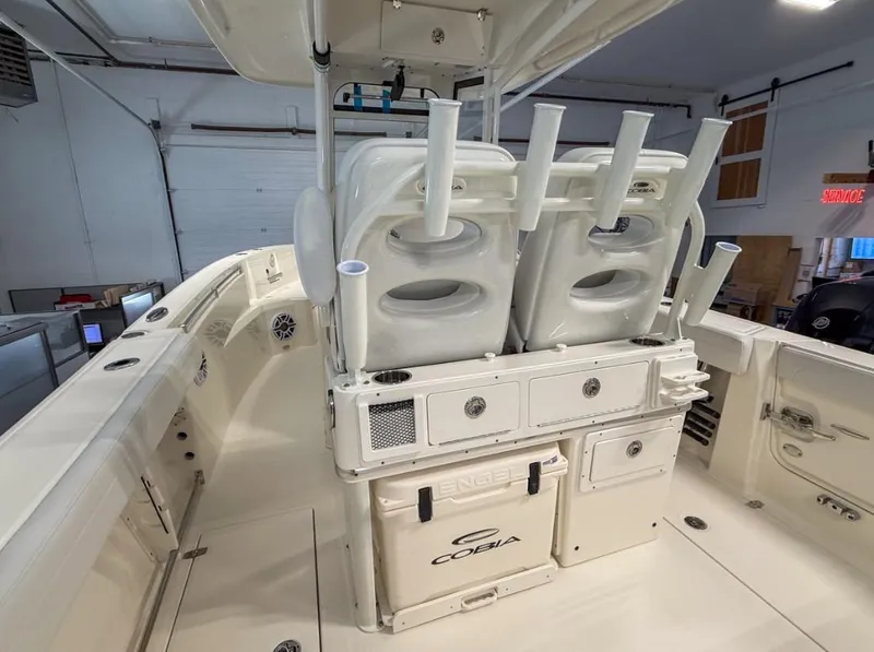 Slide: The Image of 2025 Cobia 265 Open Center Console boat interior with rod holders and storage compartments. - 11
