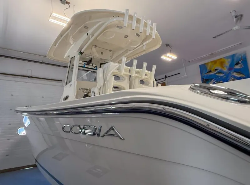 Slide: The Image of 2025 Cobia 265 Open Center Console boat in showroom, showcasing sleek design and modern features. - 2