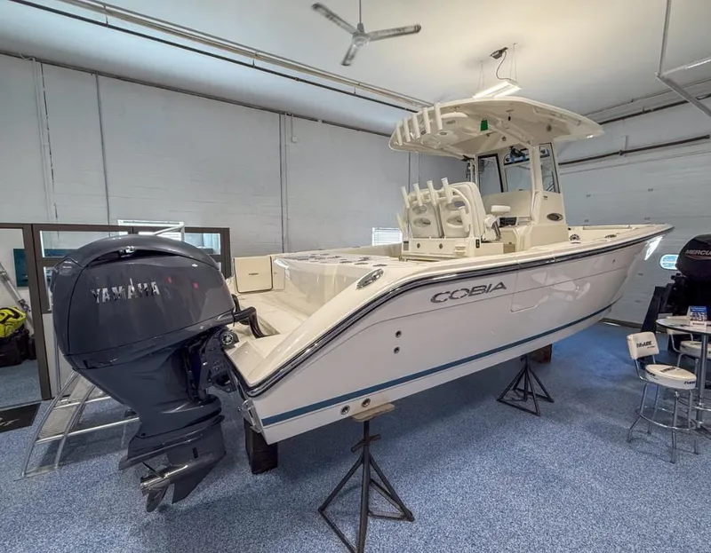 Slide: The Image of 2025 Cobia 265 Open Center Console boat in showroom with Yamaha engine. - 3