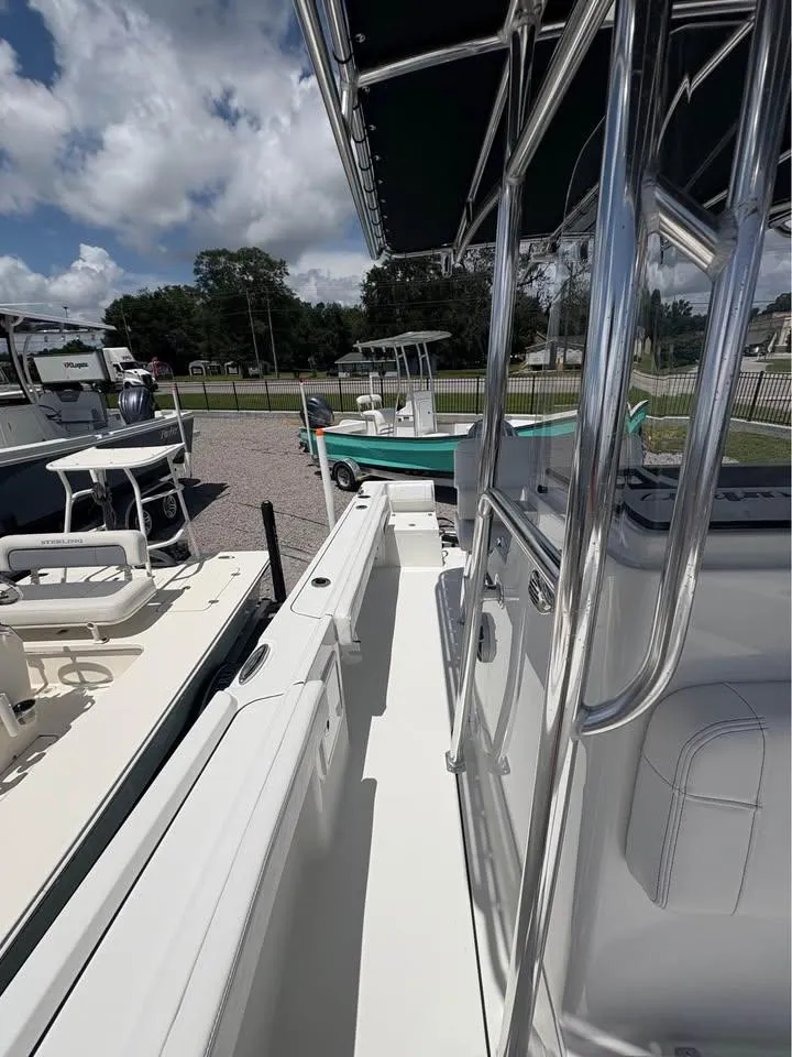 Slide: The Image of 2026 Parker 210 COASTAL boat with sleek design, docked under a cloudy sky. - 15