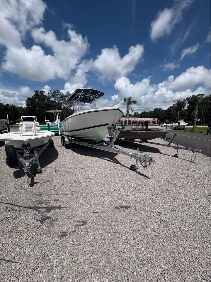 Slide: The Image of 2026 Parker 210 COASTAL boat on trailer under a partly cloudy sky. - 5