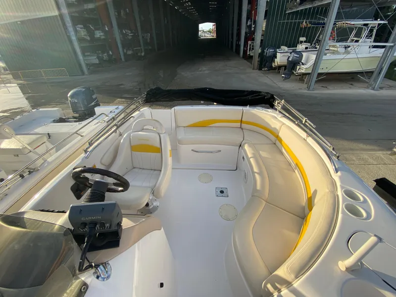 Slide: The Image of 2001 Chaparral Sunesta 232 boat interior with seating and steering wheel in a marina setting. - 11