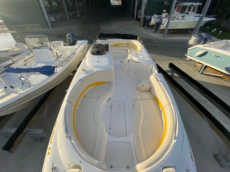 Slide: The Image of 2001 Chaparral Sunesta 232 boat with yellow-accented seating, docked in a marina. - 12
