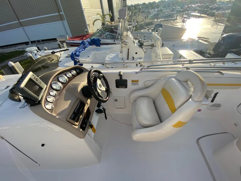 Slide: The Image of 2001 Chaparral Sunesta 232 boat cockpit with steering wheel and gauges, docked at marina. - 20